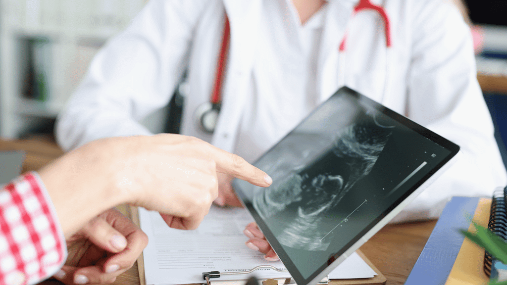 doctor and patient looking a ipad of ultrasound