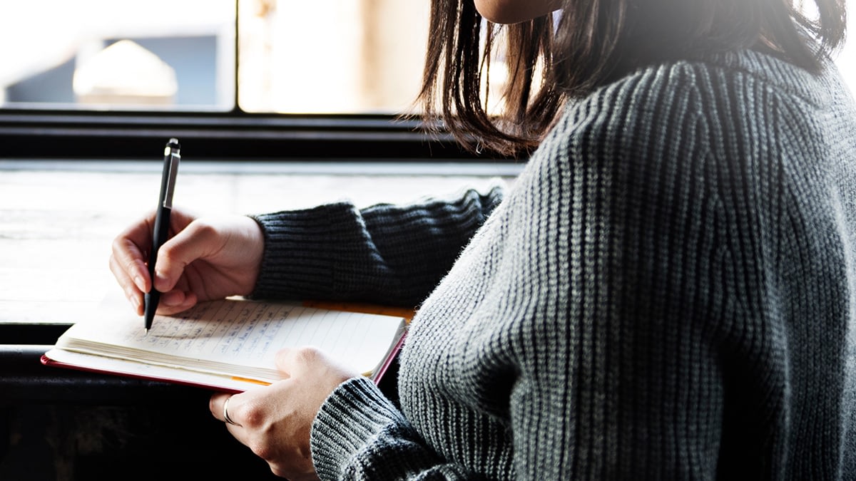 Photo of woman writing in a journal