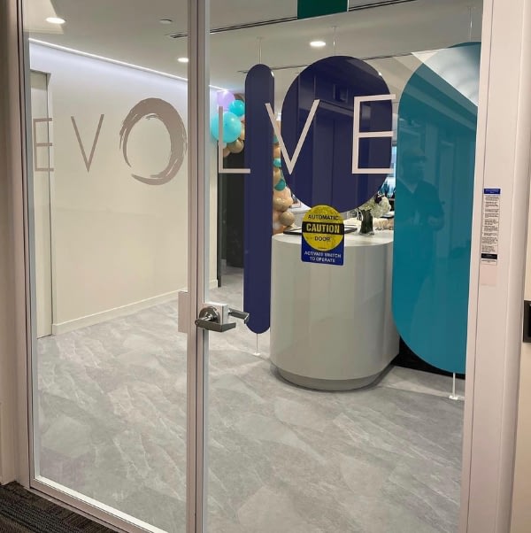 EVOLVE logo in front of see through door looking into clinic