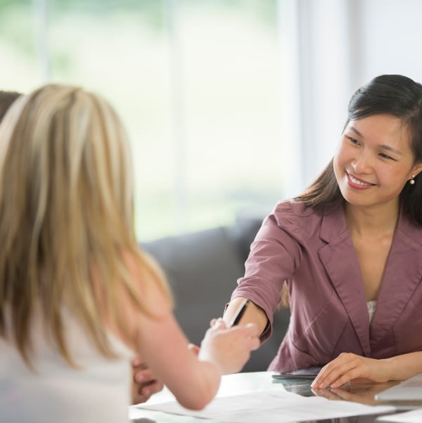 two women talking over papers, financial planning