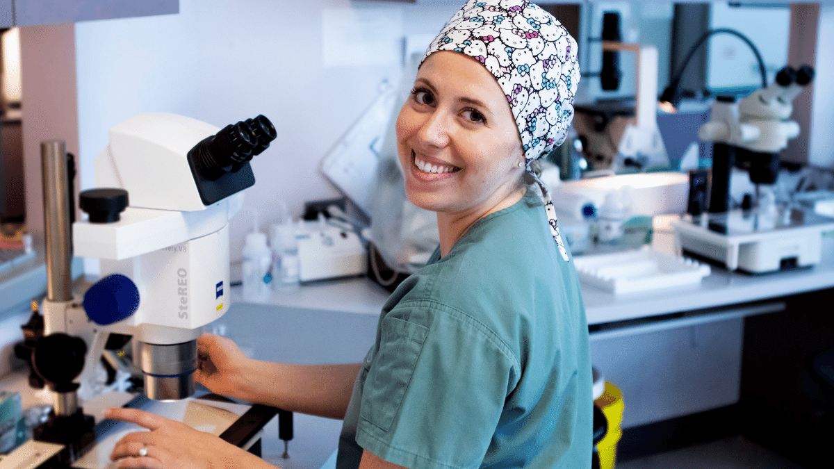 female lab technician sitting at an IVF microscope