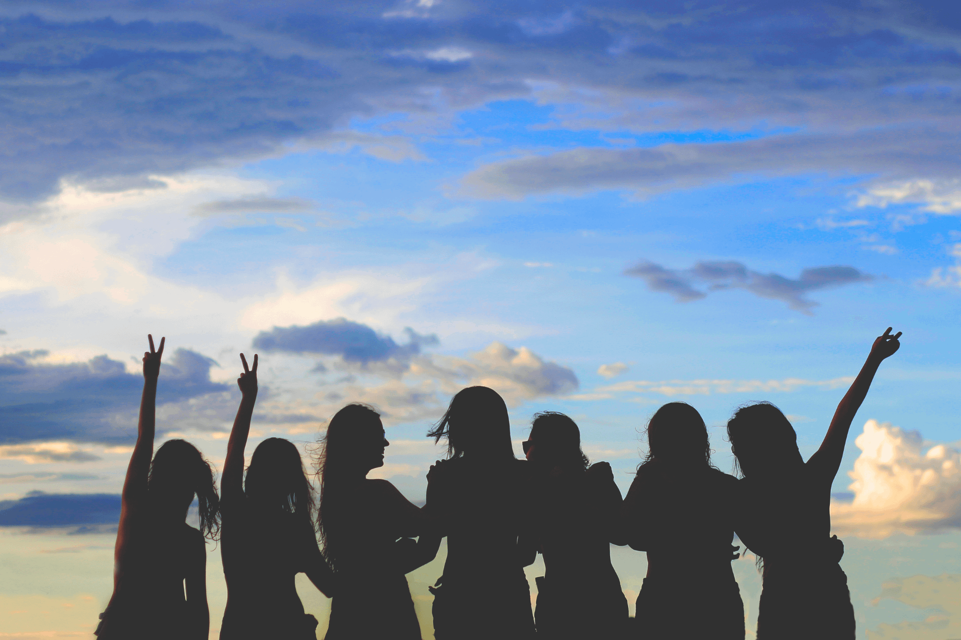 Group of women photo with shadows and beach sky behind them