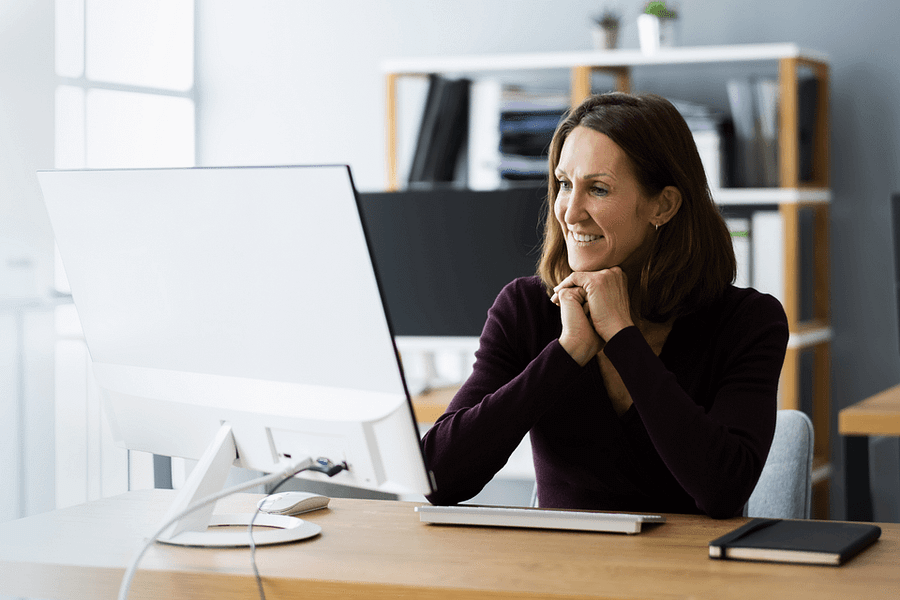 Women with brown hair smiling watching desktop screen