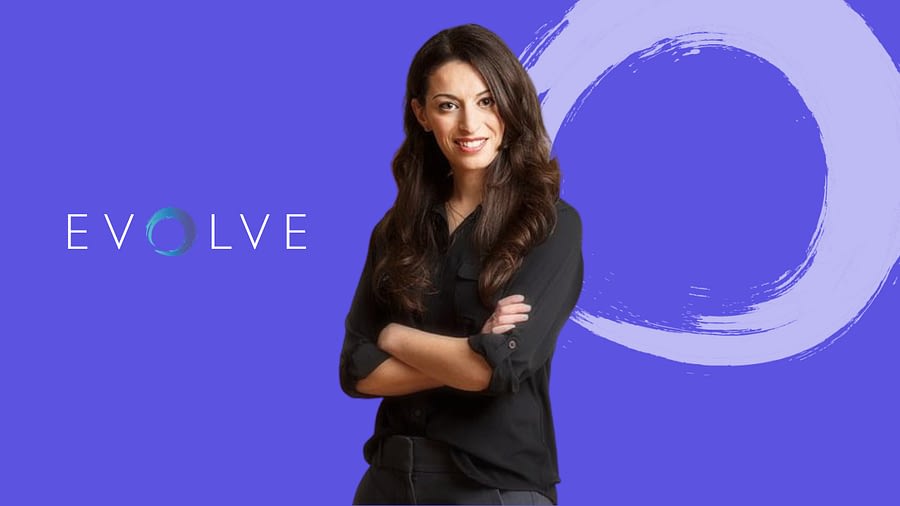 Photo of Dr. Greenberg with black shirt, arms crossed and smiling, purple background and evolve logo